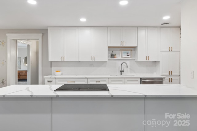 kitchen featuring light stone countertops, sink, white cabinetry, and dishwasher