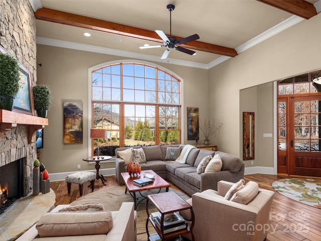 living room with ceiling fan, hardwood / wood-style flooring, ornamental molding, and a fireplace