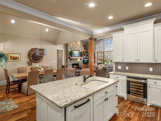 kitchen with sink, beverage cooler, and white cabinetry