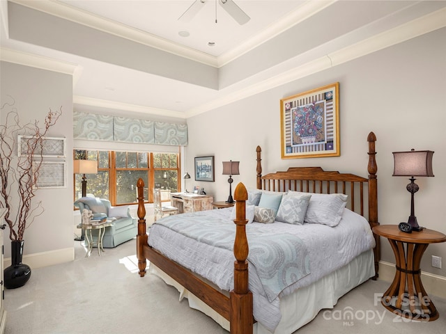 carpeted bedroom with ceiling fan, crown molding, and a raised ceiling