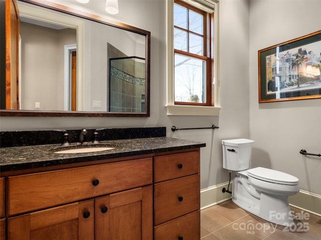 bathroom featuring tile patterned flooring, vanity, plenty of natural light, toilet, and walk in shower