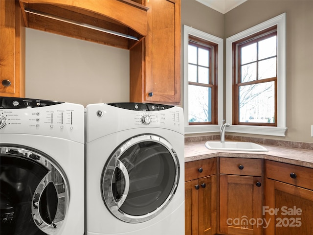 laundry area featuring cabinets, sink, and washing machine and clothes dryer