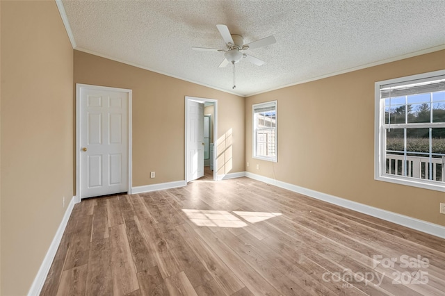 unfurnished room with light wood-type flooring, vaulted ceiling, crown molding, and a textured ceiling