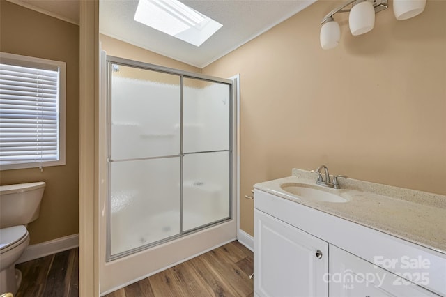 bathroom with toilet, walk in shower, hardwood / wood-style floors, and vaulted ceiling with skylight