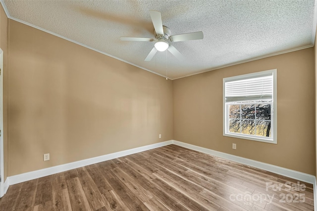 spare room featuring ceiling fan, wood-type flooring, ornamental molding, and a textured ceiling