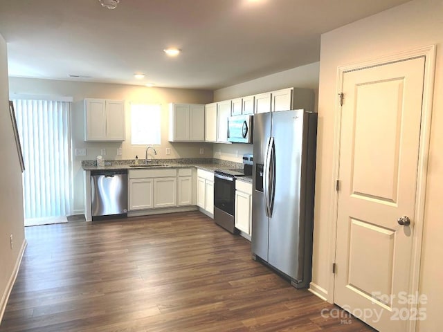 kitchen featuring appliances with stainless steel finishes, white cabinetry, dark hardwood / wood-style floors, and sink