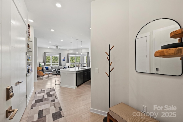 hallway with sink and light hardwood / wood-style flooring