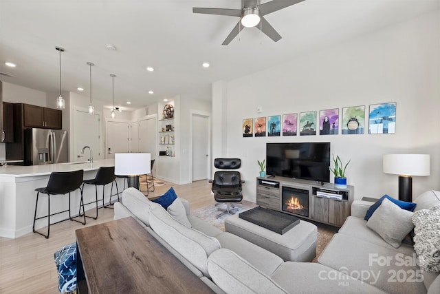 living room with ceiling fan and light hardwood / wood-style floors