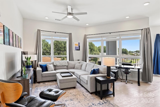 living room featuring ceiling fan and light hardwood / wood-style flooring