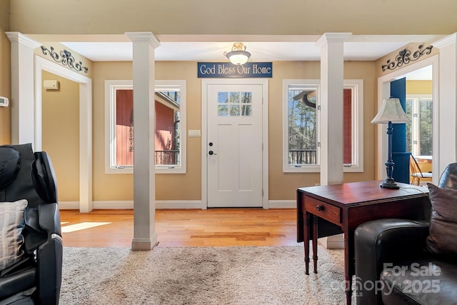 foyer with decorative columns, wood-type flooring, and a wealth of natural light