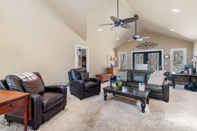 living room featuring ceiling fan, high vaulted ceiling, and light carpet