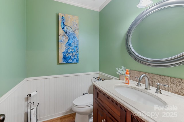 bathroom featuring vanity, crown molding, toilet, and hardwood / wood-style flooring