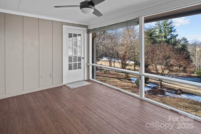 unfurnished sunroom with ceiling fan