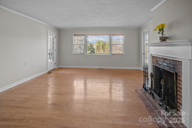 unfurnished living room featuring a brick fireplace, crown molding, and hardwood / wood-style floors