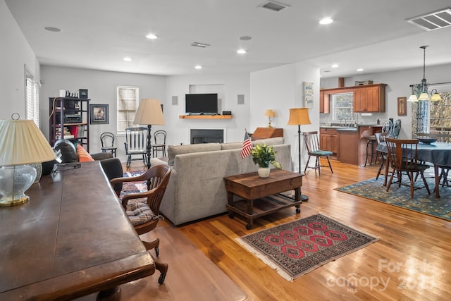 living room with light hardwood / wood-style flooring and a notable chandelier