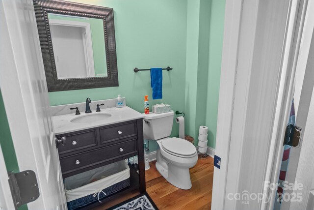 bathroom with toilet, vanity, and hardwood / wood-style flooring