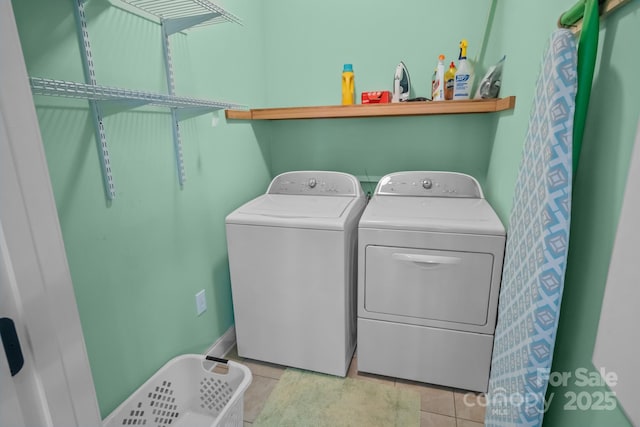 laundry area with washer and clothes dryer and light tile patterned flooring