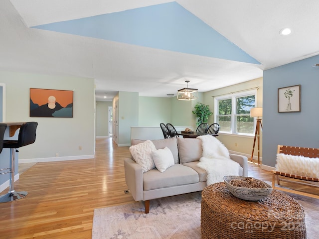 living room featuring vaulted ceiling and hardwood / wood-style flooring