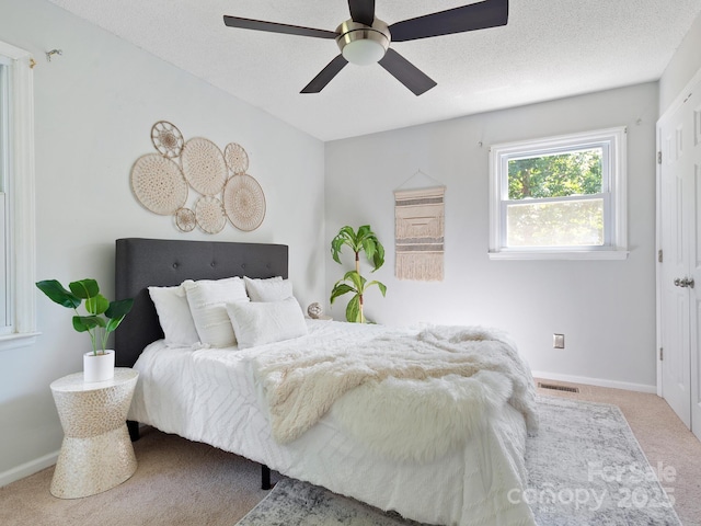 carpeted bedroom with a textured ceiling and ceiling fan