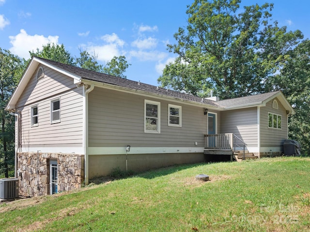 rear view of house featuring central AC unit and a lawn