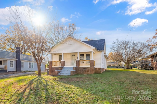 view of front of property featuring french doors, covered porch, and a front yard