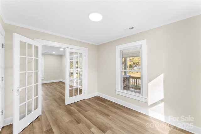 interior space with hardwood / wood-style flooring, crown molding, and french doors