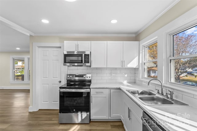 kitchen with appliances with stainless steel finishes, dark hardwood / wood-style floors, backsplash, white cabinets, and sink