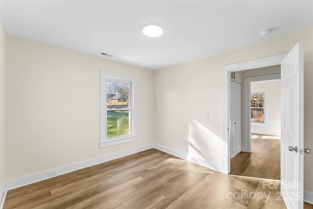 unfurnished room with hardwood / wood-style flooring