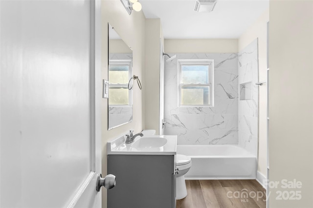 full bathroom with toilet, vanity, a wealth of natural light, and hardwood / wood-style floors