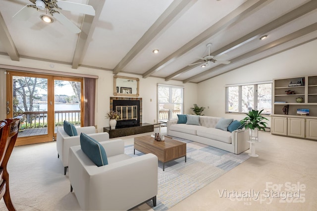 living room featuring ceiling fan, light colored carpet, a high end fireplace, and vaulted ceiling with beams