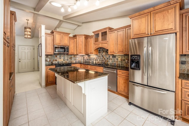 kitchen with a kitchen island, stainless steel appliances, vaulted ceiling with beams, dark stone countertops, and sink