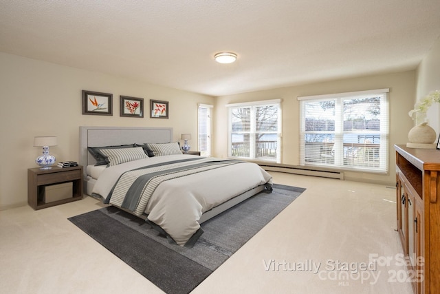 bedroom featuring light colored carpet and a baseboard heating unit