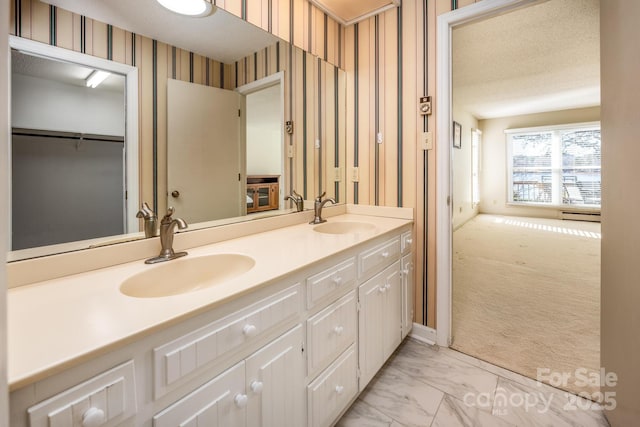 bathroom featuring a textured ceiling, baseboard heating, and vanity