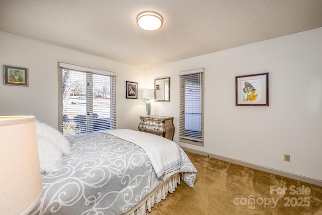 bedroom featuring light carpet and a textured ceiling