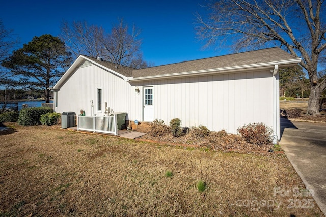 view of side of property featuring a lawn and central air condition unit