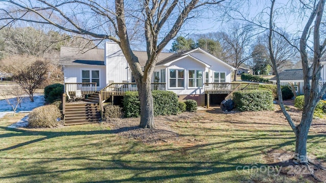 back of house featuring a wooden deck and a yard