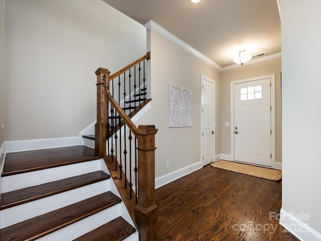 entrance foyer featuring ornamental molding and dark hardwood / wood-style floors