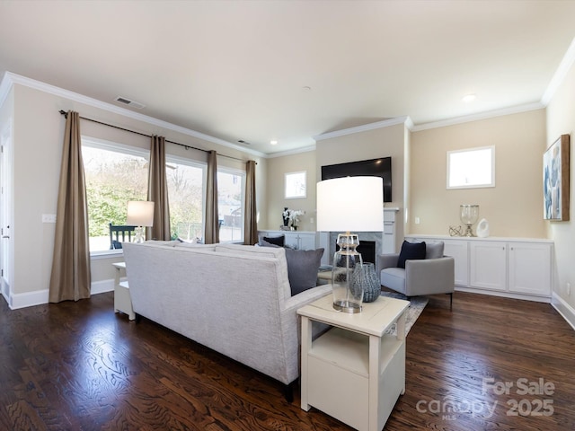 living room featuring crown molding, a healthy amount of sunlight, and dark hardwood / wood-style flooring