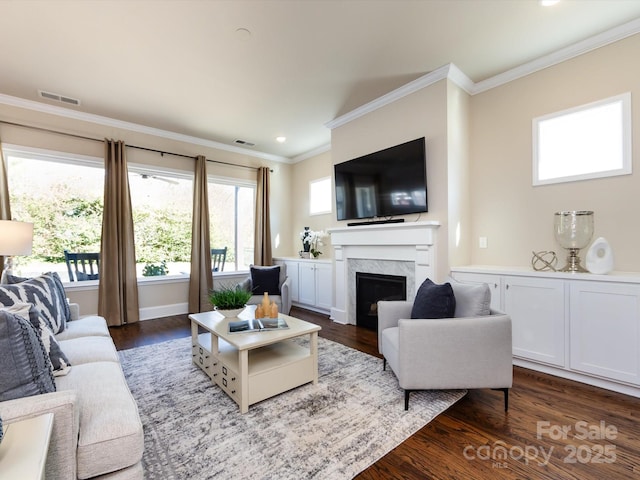 living room featuring dark hardwood / wood-style floors, ornamental molding, and a premium fireplace