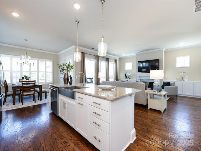 kitchen with sink, hanging light fixtures, a center island with sink, stainless steel dishwasher, and white cabinets