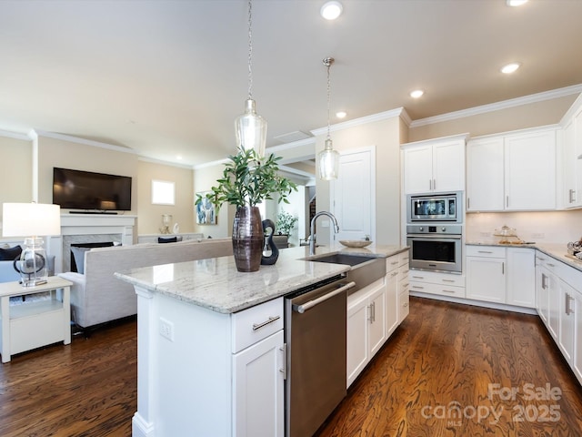 kitchen with stainless steel appliances, white cabinetry, a kitchen island with sink, and decorative light fixtures