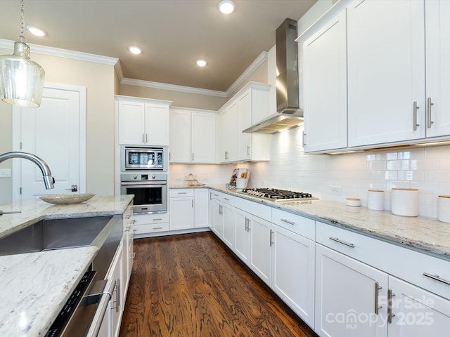 kitchen with wall chimney exhaust hood, decorative light fixtures, stainless steel appliances, light stone countertops, and white cabinets