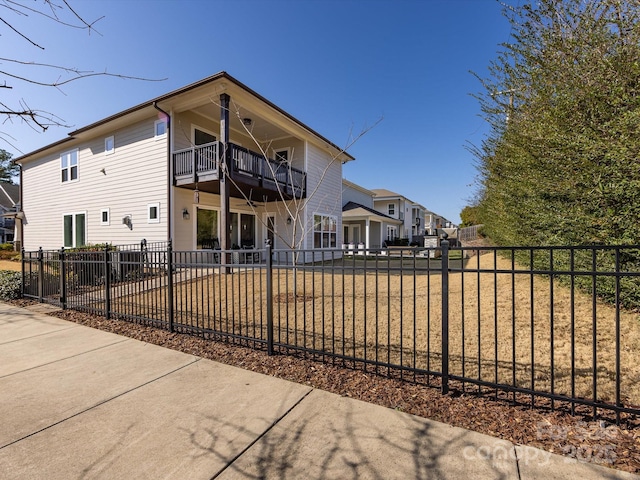 view of front of home with a balcony and a front lawn