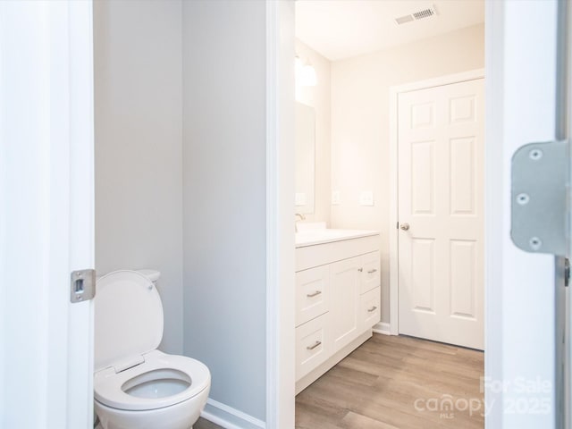 bathroom featuring hardwood / wood-style flooring, toilet, and vanity