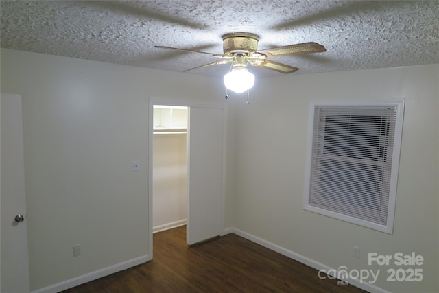 spare room with ceiling fan, a textured ceiling, and dark hardwood / wood-style floors