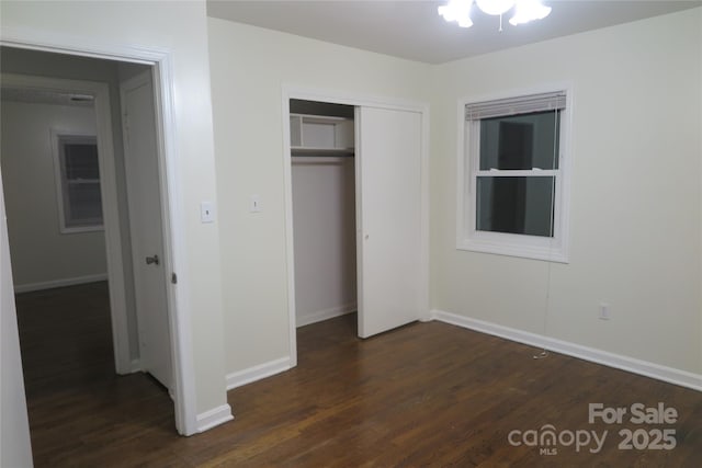 unfurnished bedroom featuring dark wood-type flooring and a closet