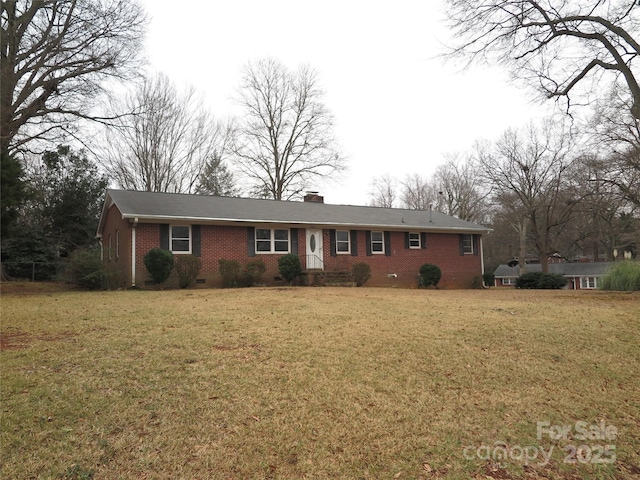 ranch-style home with brick siding, a front yard, and a chimney