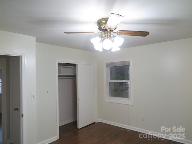 unfurnished bedroom with baseboards, a closet, ceiling fan, and dark wood-style flooring