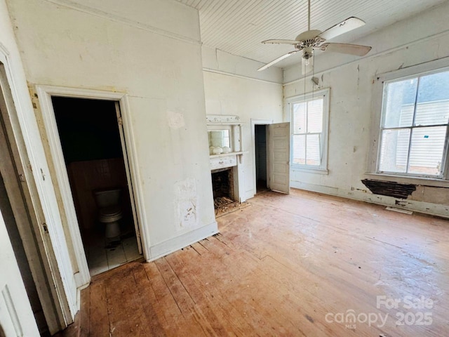 unfurnished bedroom with hardwood / wood-style flooring, ceiling fan, and connected bathroom