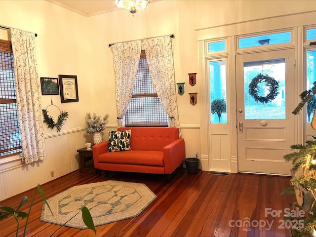 entrance foyer with dark hardwood / wood-style floors and crown molding